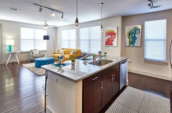 A modern kitchen with a large island and a dining area.at Century Cedar Hill, Cedar Hill
